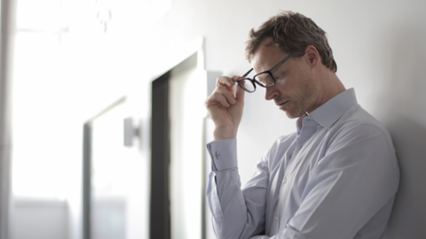 An unmotivated man in a shirt and with glasses