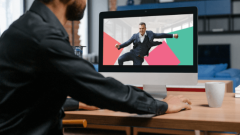 The laptop screen displays the happy man, the workplace happiness consultant