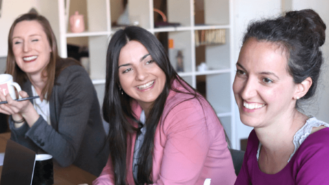 Photo of three happy employees laughing featuring the importance of keeping employees happy and satisfied