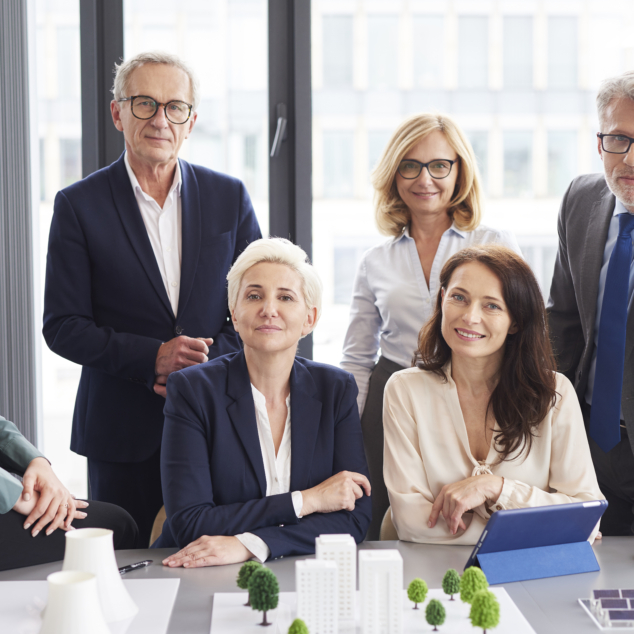 six women and men in suits posing for picture