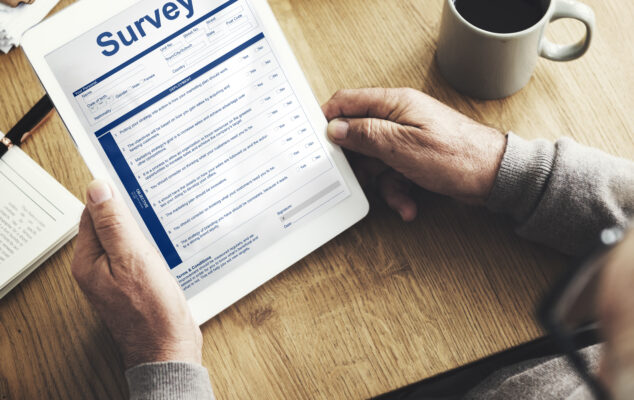 Person filling out an employee survey on a tablet using one of the best employee survey tools