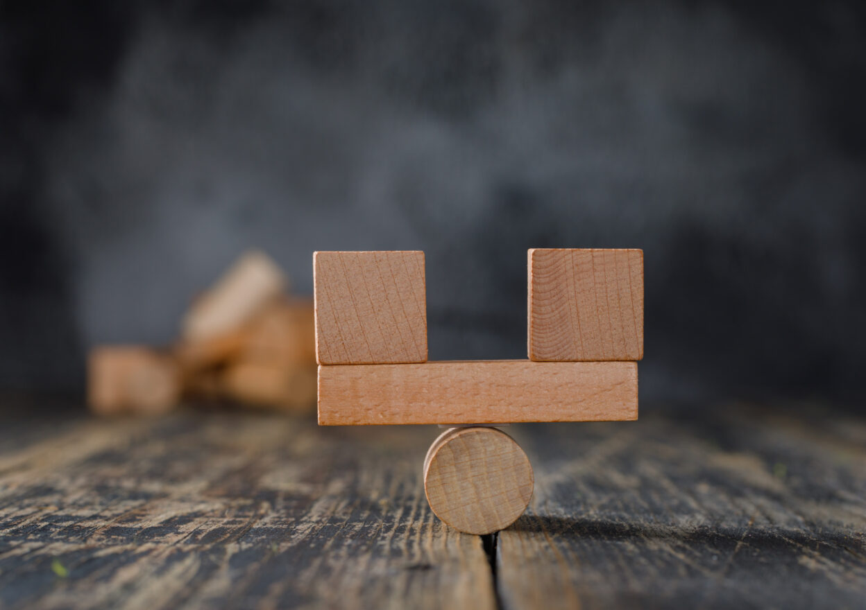 Balanced wooden blocks on a pivot symbolizing 15Five vs Workleap comparison in employee engagement software.