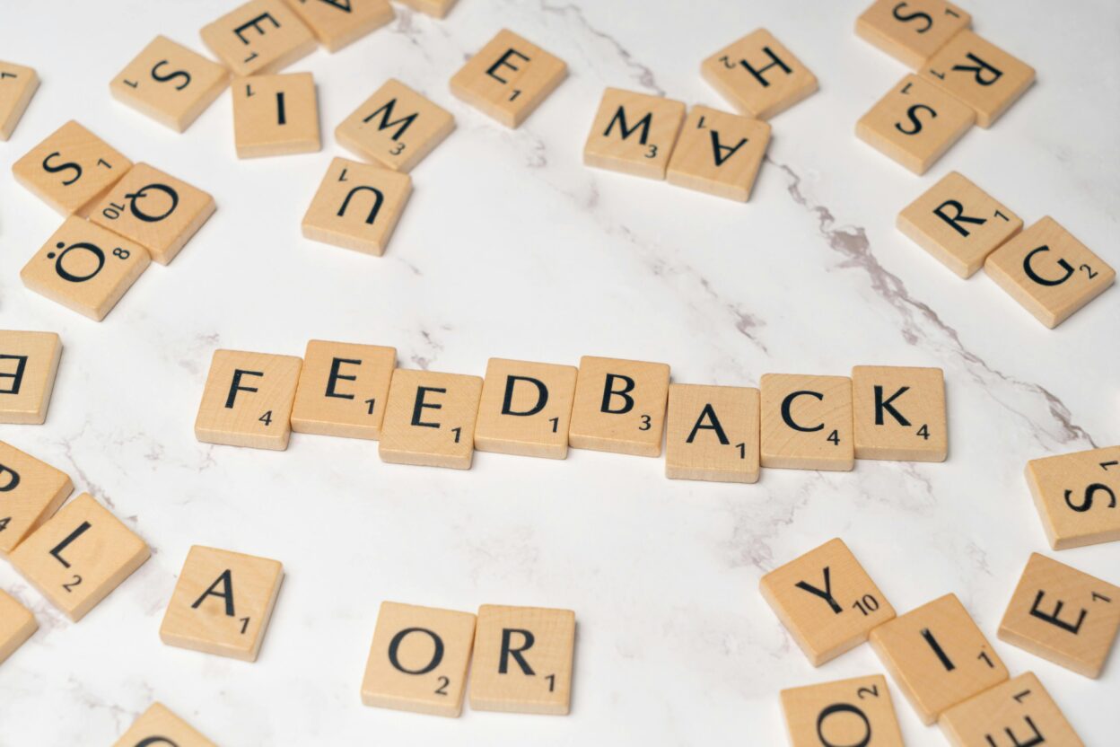 Lattice review concept showing feedback spelled with letter tiles representing performance reviews and continuous feedback