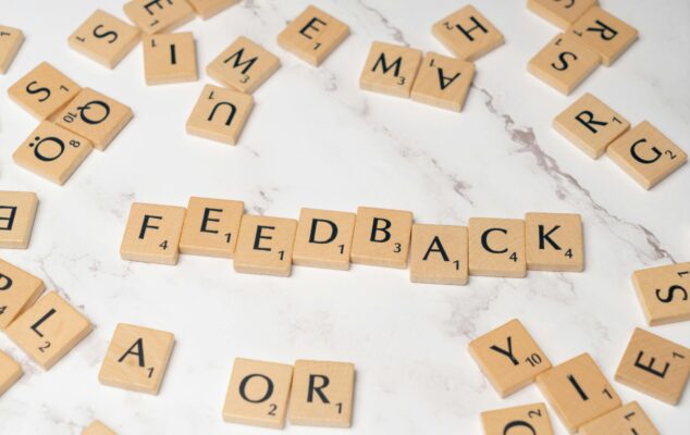 Lattice review concept showing feedback spelled with letter tiles representing performance reviews and continuous feedback
